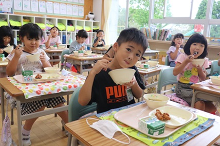 学校給食で有機米をほおばる子どもたちの写真